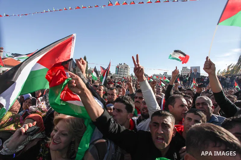 Palestinians wave national flags as they celebrate their successful bid for UN non-member observer state status, in the West Bank city of Ramallah on December 2, 2012, Palestinian President Mahmoud Abbas arrived to the W...