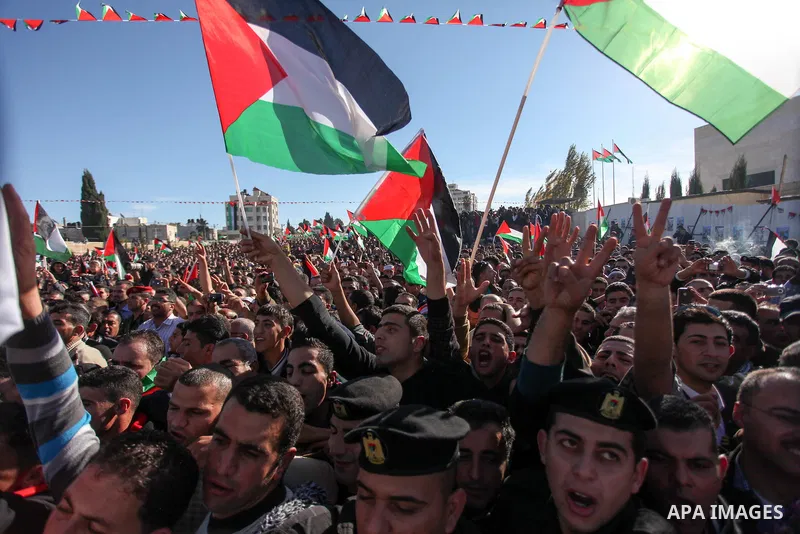 Palestinians wave national flags as they celebrate their successful bid for UN non-member observer state status, in the West Bank city of Ramallah on December 2, 2012, Palestinian President Mahmoud Abbas arrived to the W...