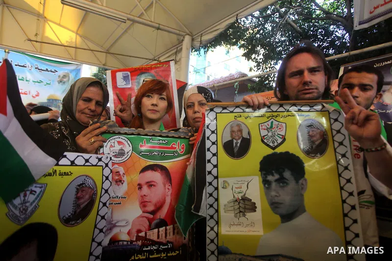 Palestinian women hold pictures of their prisoned relatives in Israeli jails as they gather in a weekly activity calling for their liberty at the Red Cross headquarters in Gaza City on December 03, 2012. Photo by Ashraf...