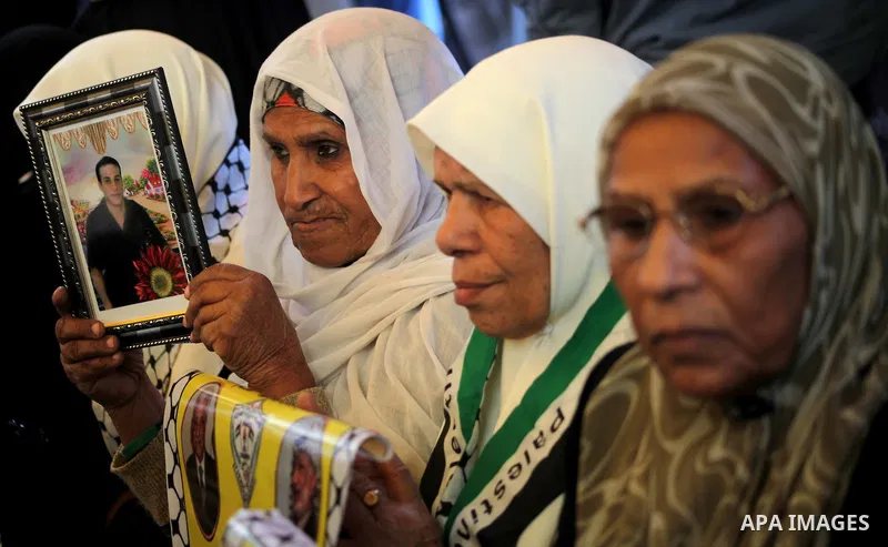 Palestinian women hold pictures of their prisoned relatives in Israeli jails as they gather in a weekly activity calling for their liberty at the Red Cross headquarters in Gaza City on December 03, 2012. Photo by Ashraf...