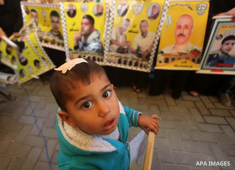Palestinian women hold pictures of their prisoned relatives in Israeli jails as they gather in a weekly activity calling for their liberty at the Red Cross headquarters in Gaza City on December 03, 2012. Photo by Ashraf...