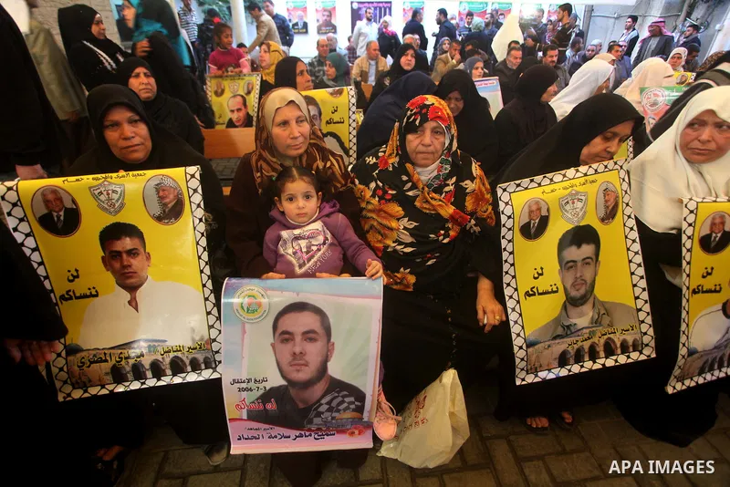 Palestinians hold pictures of their prisoned relatives in Israeli jails as they gather in a weekly activity calling for their liberty at the Red Cross headquarters in Gaza City on December 03, 2012. Photo by Ashraf Amra