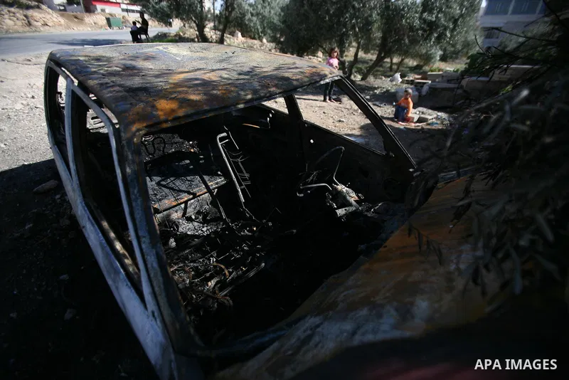 A Palestinian man inspects his car burned by Israeli settlers in the West Bank city of Hebron, on Dec. 03, 2012. Photo by Mamoun Wazwaz