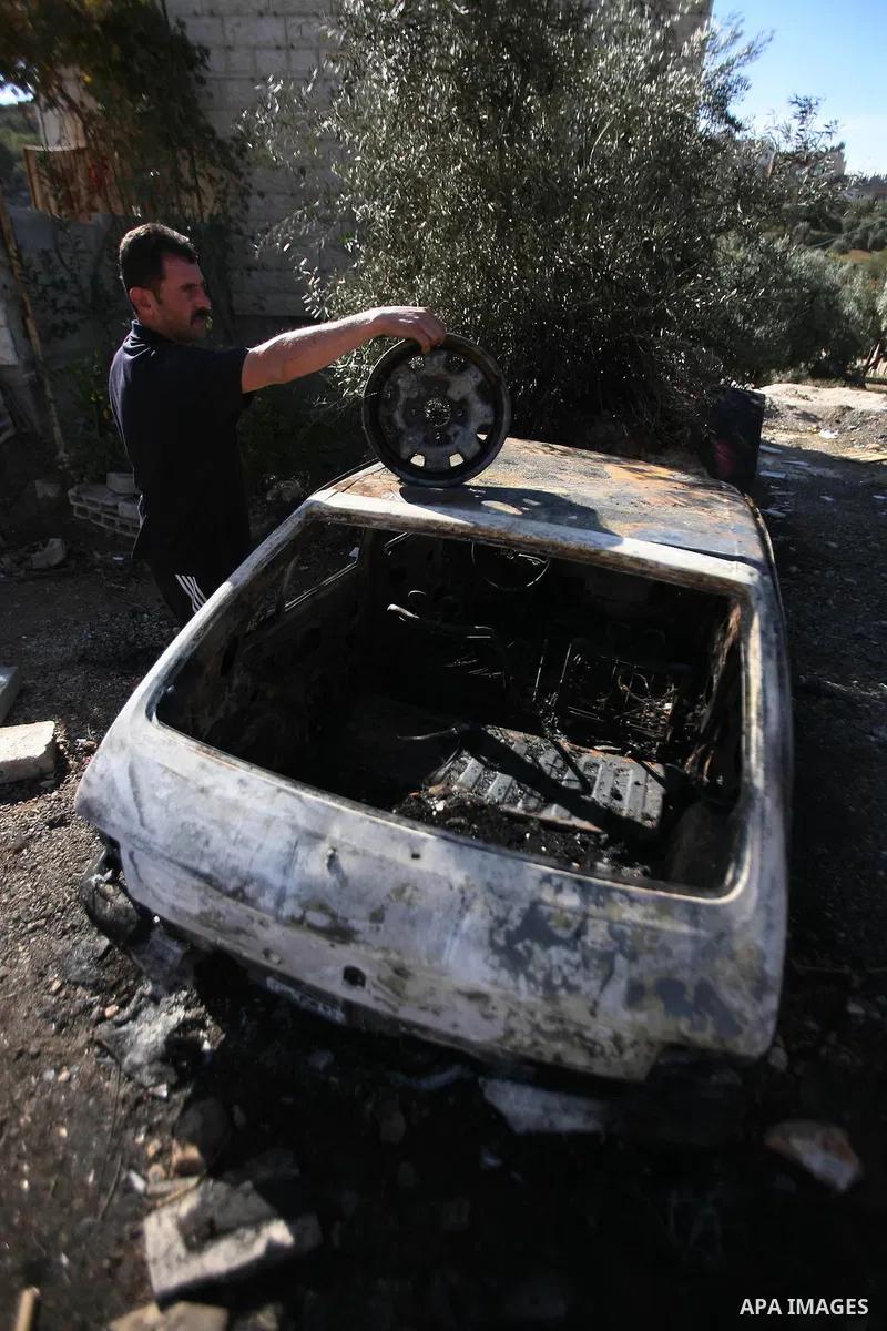 A Palestinian man inspects his car burned by Israeli settlers in the West Bank city of Hebron, on Dec. 03, 2012. Photo by Mamoun Wazwaz