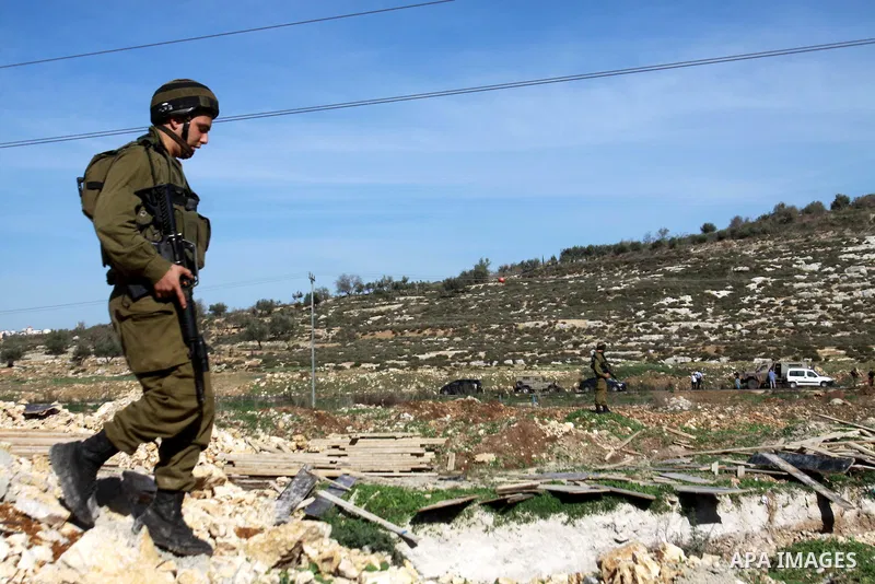 Israeli soldiers block the road after a traffic accident between cars of Israeli forces from the Shin Bet internal security agency and Hatem Shadid, a Palestinian who was shot dead earlier the agency members after he ram...