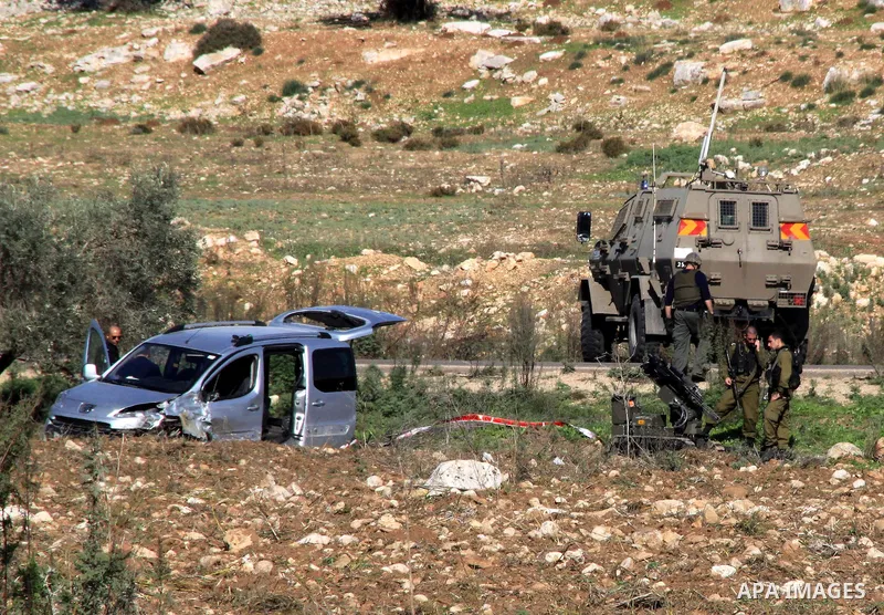Israeli soldiers inspect the damage cars of Israeli forces from the Shin Bet internal security agency and Hatem Shadid, a Palestinian who was shot dead earlier the agency members after he rammed their car and attacked th...