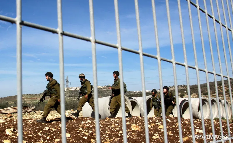 Israeli soldiers block the road after a traffic accident between cars of Israeli forces from the Shin Bet internal security agency and Hatem Shadid, a Palestinian who was shot dead earlier the agency members after he ram...