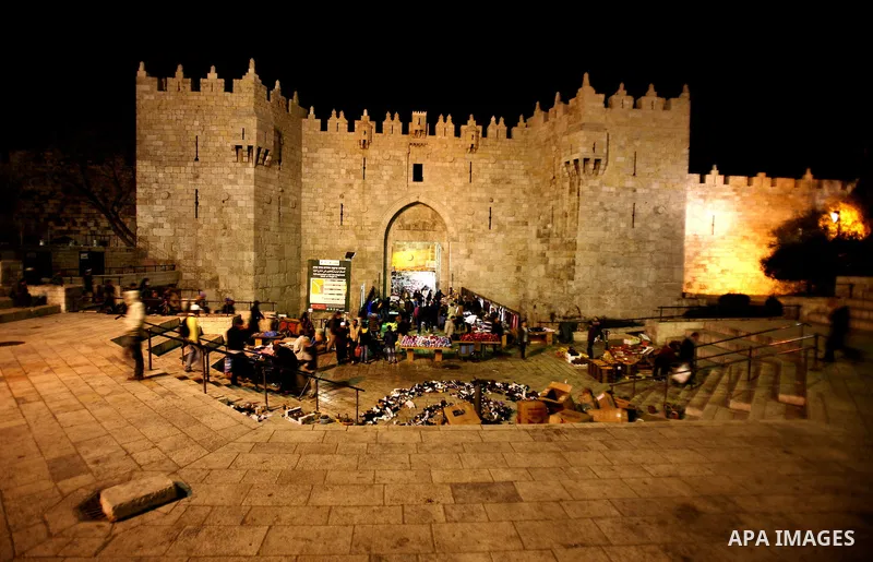 Palestinians walk at Damascus gate in front of al-Aqsa mosque Islam's third holiest site, in the old city of Jerusalem on December 03, 2012. Photo by Mahfouz Abu Turk