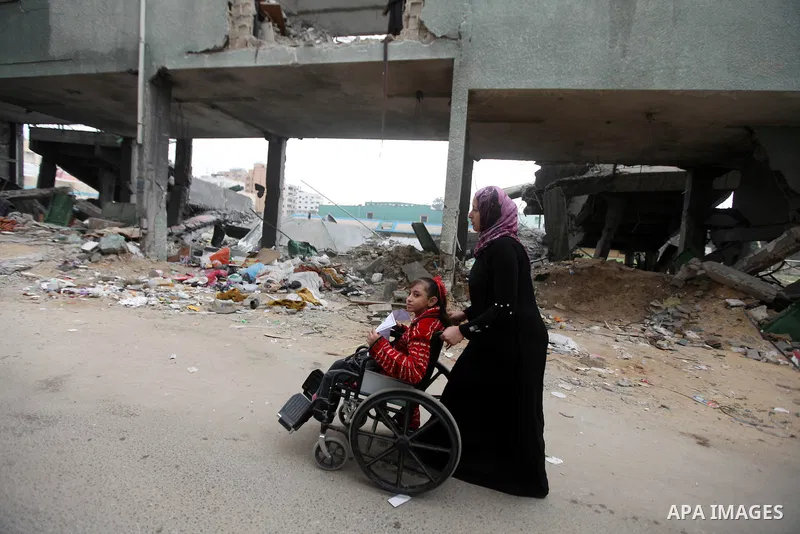 Palestinian children with special needs walk past buildings destroyed during the Gaza-Israeli conflict during a demonstration on the occasion of the UN International Day of People with Disability, on December 4, 2012 in...