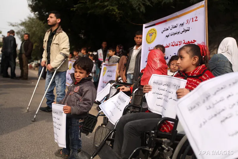 Palestinian children with special needs walk past buildings destroyed during the Gaza-Israeli conflict during a demonstration on the occasion of the UN International Day of People with Disability, on December 4, 2012 in...
