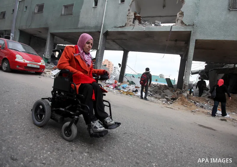 Palestinian children with special needs walk past buildings destroyed during the Gaza-Israeli conflict during a demonstration on the occasion of the UN International Day of People with Disability, on December 4, 2012 in...