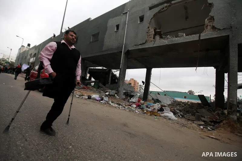 Palestinian children with special needs walk past buildings destroyed during the Gaza-Israeli conflict during a demonstration on the occasion of the UN International Day of People with Disability, on December 4, 2012 in...