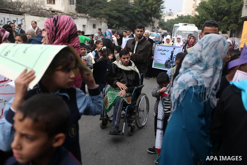 Palestinian children with special needs walk past buildings destroyed during the Gaza-Israeli conflict during a demonstration on the occasion of the UN International Day of People with Disability, on December 4, 2012 in...