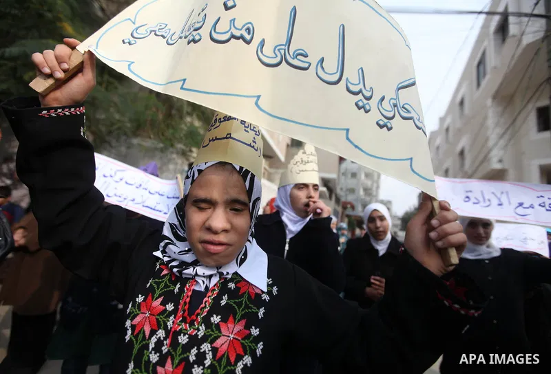Palestinian children with special needs walk past buildings destroyed during the Gaza-Israeli conflict during a demonstration on the occasion of the UN International Day of People with Disability, on December 4, 2012 in...