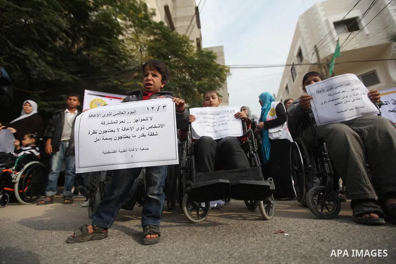 Palestinian children with special needs walk past buildings destroyed during the Gaza-Israeli conflict during a demonstration on the occasion of the UN International Day of People with Disability, on December 4, 2012 in...