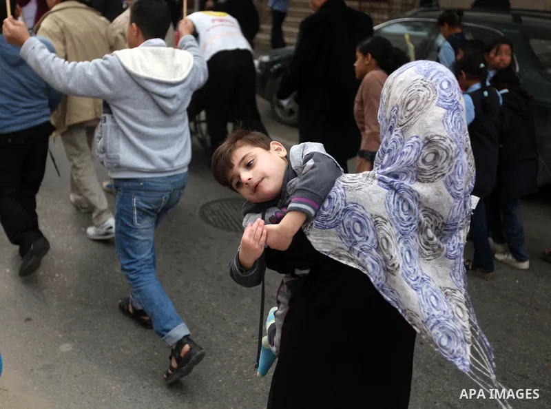 Palestinian children with special needs walk past buildings destroyed during the Gaza-Israeli conflict during a demonstration on the occasion of the UN International Day of People with Disability, on December 4, 2012 in...
