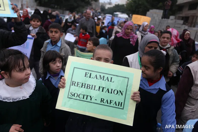 Palestinian children with special needs walk past buildings destroyed during the Gaza-Israeli conflict during a demonstration on the occasion of the UN International Day of People with Disability, on December 4, 2012 in...