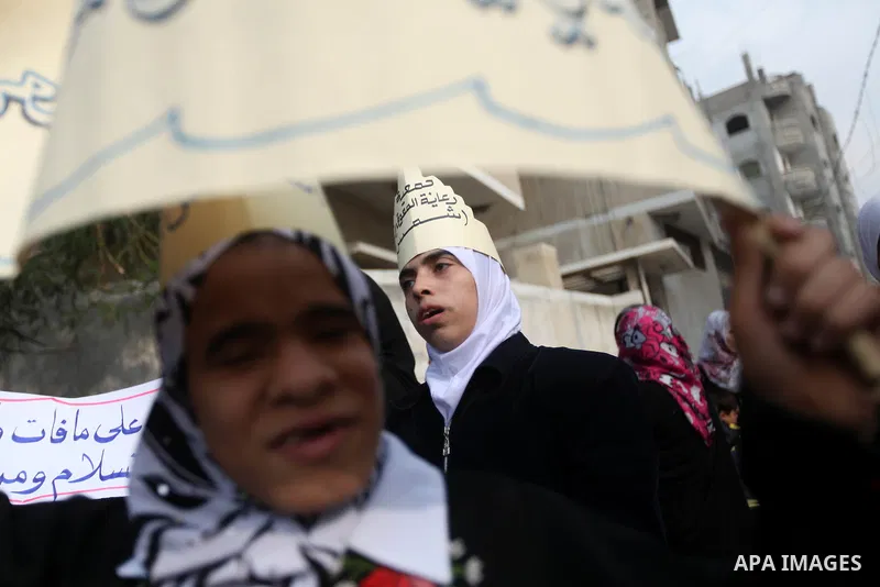 Palestinian children with special needs walk past buildings destroyed during the Gaza-Israeli conflict during a demonstration on the occasion of the UN International Day of People with Disability, on December 4, 2012 in...