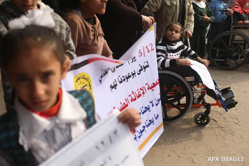 Palestinian children with special needs walk past buildings destroyed during the Gaza-Israeli conflict during a demonstration on the occasion of the UN International Day of People with Disability, on December 4, 2012 in...
