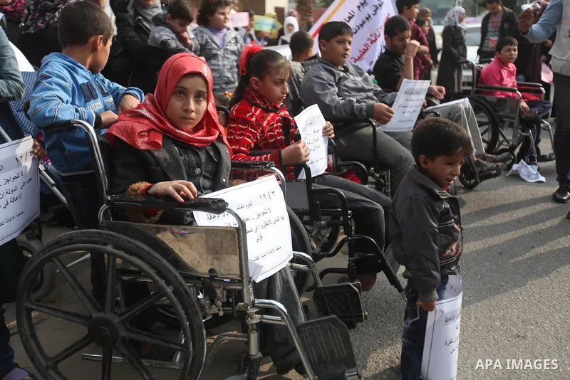 Palestinian children with special needs walk past buildings destroyed during the Gaza-Israeli conflict during a demonstration on the occasion of the UN International Day of People with Disability, on December 4, 2012 in...