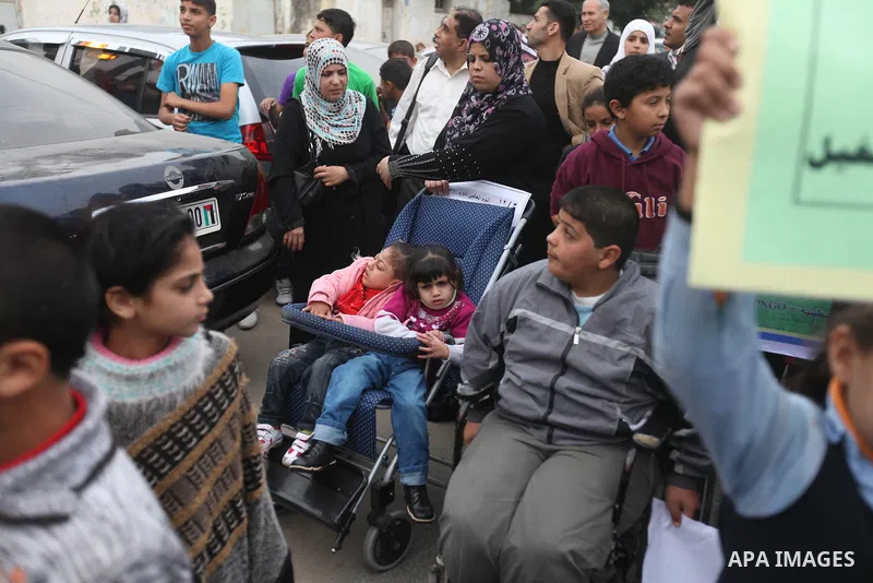 Palestinian children with special needs walk past buildings destroyed during the Gaza-Israeli conflict during a demonstration on the occasion of the UN International Day of People with Disability, on December 4, 2012 in...