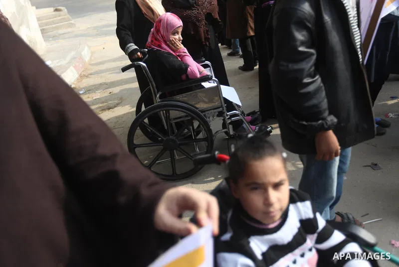 Palestinian children with special needs walk past buildings destroyed during the Gaza-Israeli conflict during a demonstration on the occasion of the UN International Day of People with Disability, on December 4, 2012 in...