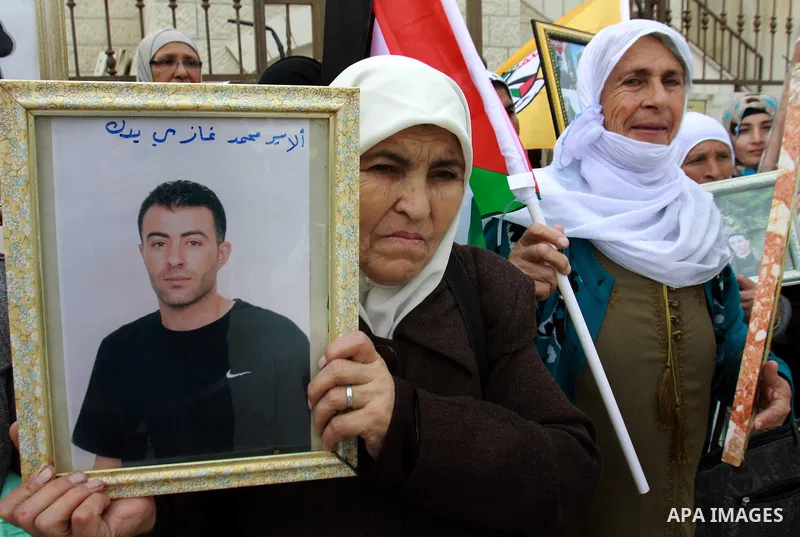Palestinians hold pictures of their prisoned relatives in Israeli jails as they gather in a weekly activity calling for their liberty at the Red Cross headquarters in the West Bank city of Nablus on December 04, 2012. Ph...