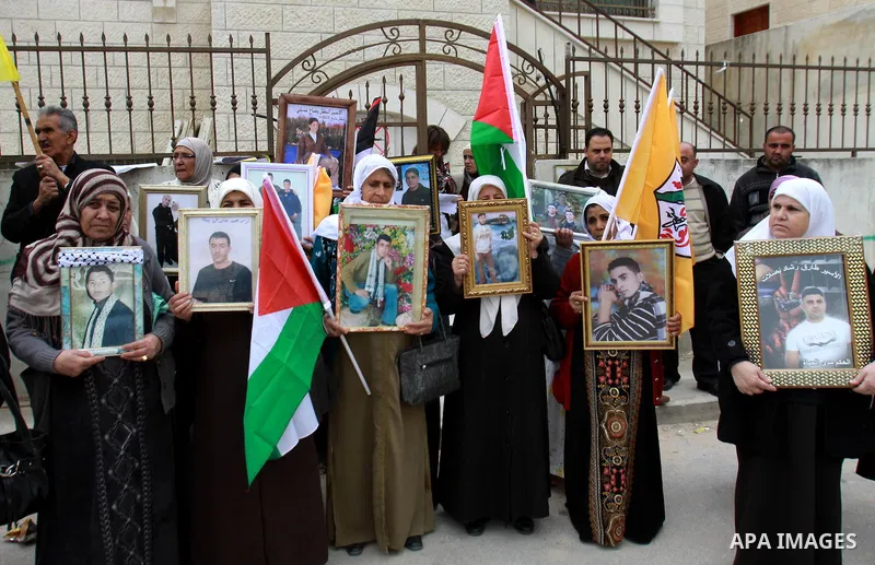 Palestinians hold pictures of their prisoned relatives in Israeli jails as they gather in a weekly activity calling for their liberty at the Red Cross headquarters in the West Bank city of Nablus on December 04, 2012. Ph...