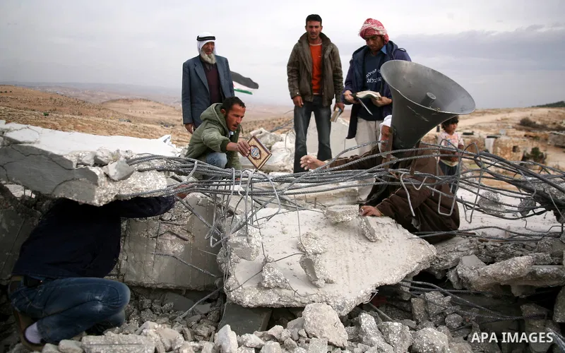 Palestinian men search through the rubble of a mosque that was demolished by Israeli forces in the West Bank village of al-Mufaqara, south of Hebron, on December 04, 2012. Photo by Mamoun Wazwaz