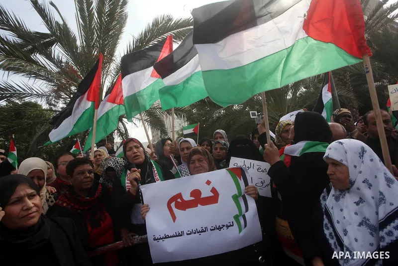 Palestinian women hold national flags during a rally to support reconciliation between rival Palestinian factions in Gaza city on 04 Dec, 2012. Palestinian President Mahmud Abbas pledged Sunday to resume efforts at recon...