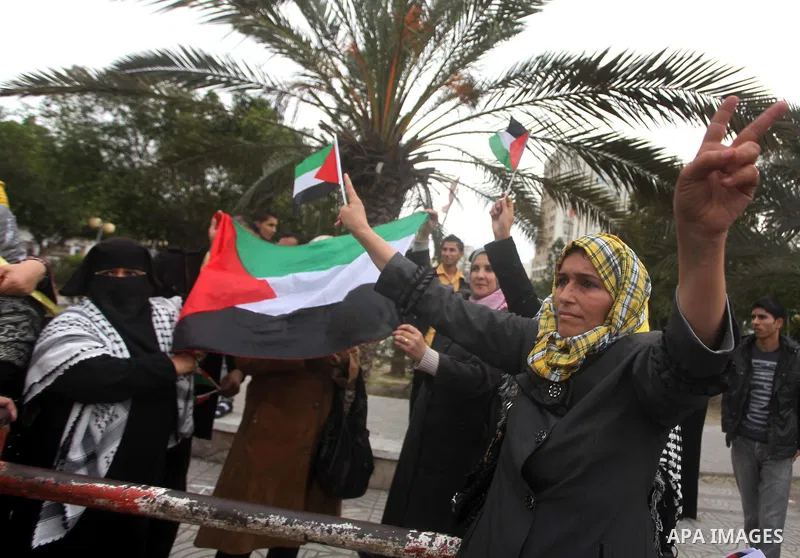 Palestinian women hold national flags during a rally to support reconciliation between rival Palestinian factions in Gaza city on 04 Dec, 2012. Palestinian President Mahmud Abbas pledged Sunday to resume efforts at recon...