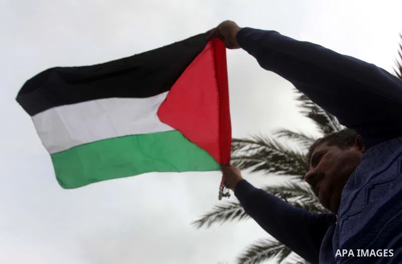 A Palestinian man holds national flag during a rally to support reconciliation between rival Palestinian factions in Gaza city on 04 Dec, 2012. Palestinian president Mahmud Abbas pledged Sunday to resume efforts at recon...