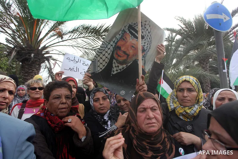 Palestinian women hold national flags during a rally to support reconciliation between rival Palestinian factions in Gaza city on 04 Dec, 2012. Palestinian President Mahmud Abbas pledged Sunday to resume efforts at recon...
