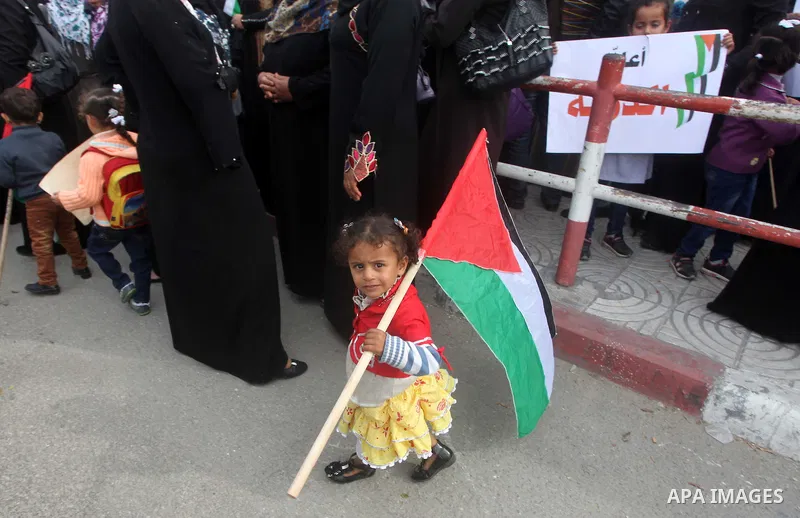 A Palestinian baby girl holds national flag during a rally to support reconciliation between rival Palestinian factions in Gaza city on 04 Dec, 2012. Palestinian president Mahmud Abbas pledged Sunday to resume efforts at...