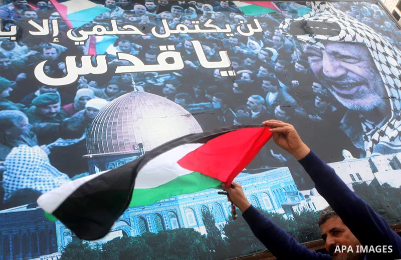 A Palestinian man holds national flag during a rally to support reconciliation between rival Palestinian factions in Gaza city on 04 Dec, 2012. Palestinian president Mahmud Abbas pledged Sunday to resume efforts at recon...