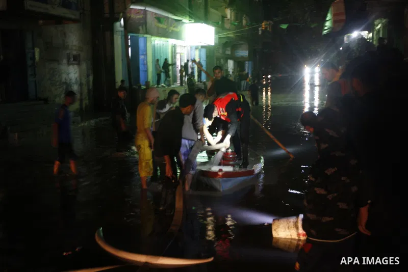 Palestinians walk at a pool of rain water in El-Shati' refugee camp in Gaza city, on Dec. 04, 2011. the onset of winter in the Palestinian territories. Photo by Mahmud Nassar