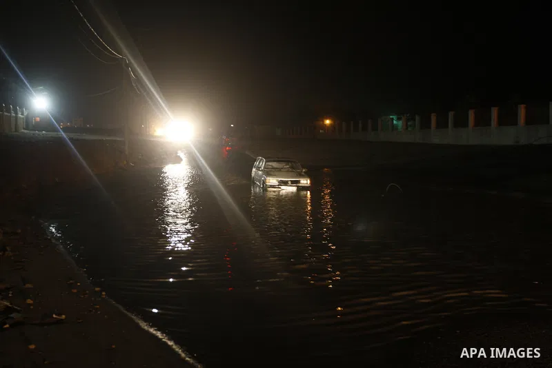 Palestinians walk at a pool of rain water in El-Shati' refugee camp in Gaza city, on Dec. 04, 2011. the onset of winter in the Palestinian territories. Photo by Mahmud Nassar