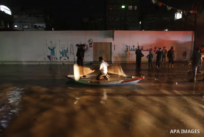 Palestinians walk at a pool of rain water in El-Shati' refugee camp in Gaza city, on Dec. 04, 2011. the onset of winter in the Palestinian territories. Photo by Mahmud Nassar