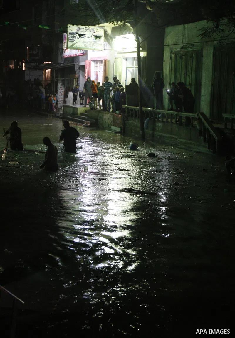 Palestinians walk at a pool of rain water in El-Shati' refugee camp in Gaza city, on Dec. 04, 2011. the onset of winter in the Palestinian territories. Photo by Mahmud Nassar