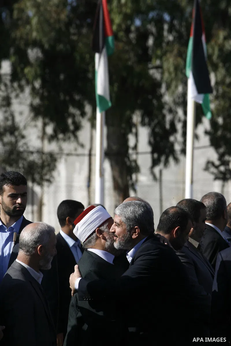 Hamas chief Khaled Meshaal hugs a Palestinian man upon his arrival in Rafah, southern Gaza, on December 7, 2012. Meshaal is making his first-ever visit to the Gaza Strip amid tight security for festivities marking the ru...