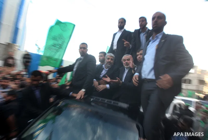 Hamas chief Khaled Meshaal, riding in a car with Palestinian prime minister in Gaza Strip Ismail Haniyeh, waves to the crowd upon his arrival in Gaza City December 7, 2012. Meshaal is making his first-ever visit to the G...