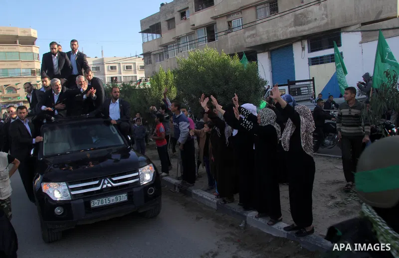 Hamas chief Khaled Meshaal, riding in a car with Palestinian prime minister in Gaza Strip Ismail Haniyeh, waves to the crowd upon his arrival in Gaza City December 7, 2012. Meshaal is making his first-ever visit to the G...
