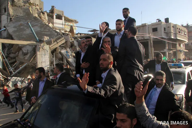 Hamas chief Khaled Meshaal, riding in a car with Palestinian prime minister in Gaza Strip Ismail Haniyeh, waves to the crowd upon his arrival in Gaza City December 7, 2012. Meshaal is making his first-ever visit to the G...