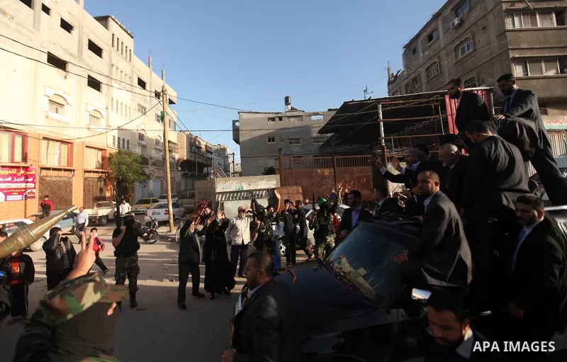 Hamas chief Khaled Meshaal, riding in a car with Palestinian prime minister in Gaza Strip Ismail Haniyeh, waves to the crowd upon his arrival in Gaza City December 7, 2012. Meshaal is making his first-ever visit to the G...