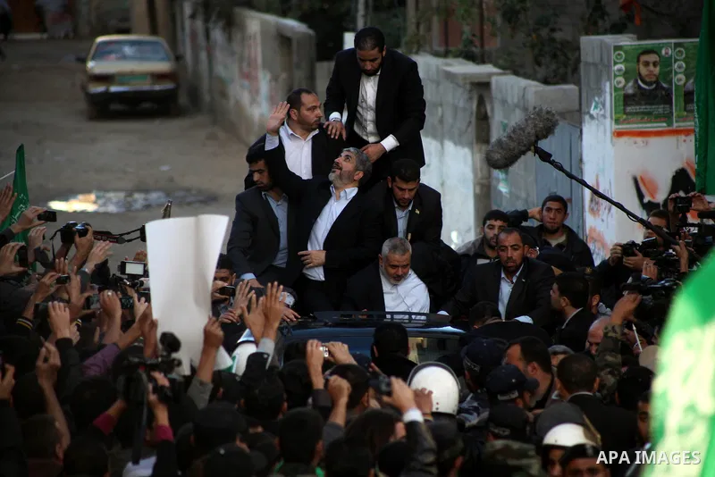 Hamas chief Khaled Meshaal, riding in a car with Palestinian prime minister in Gaza Strip Ismail Haniyeh, waves to the crowd upon his arrival in Gaza City December 7, 2012. Meshaal is making his first-ever visit to the G...
