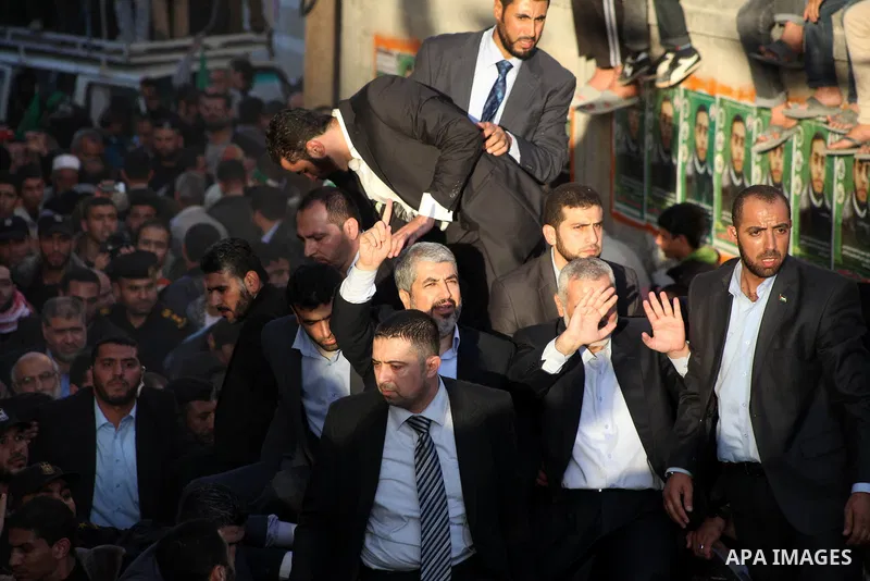 Hamas chief Khaled Meshaal, riding in a car with Palestinian prime minister in Gaza Strip Ismail Haniyeh, waves to the crowd upon his arrival in Gaza City December 7, 2012. Meshaal is making his first-ever visit to the G...