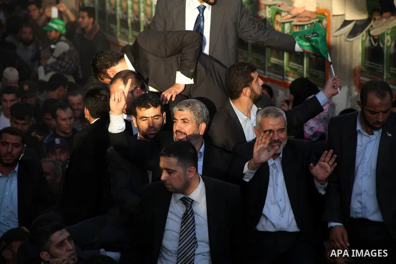 Hamas chief Khaled Meshaal, riding in a car with Palestinian prime minister in Gaza Strip Ismail Haniyeh, waves to the crowd upon his arrival in Gaza City December 7, 2012. Meshaal is making his first-ever visit to the G...