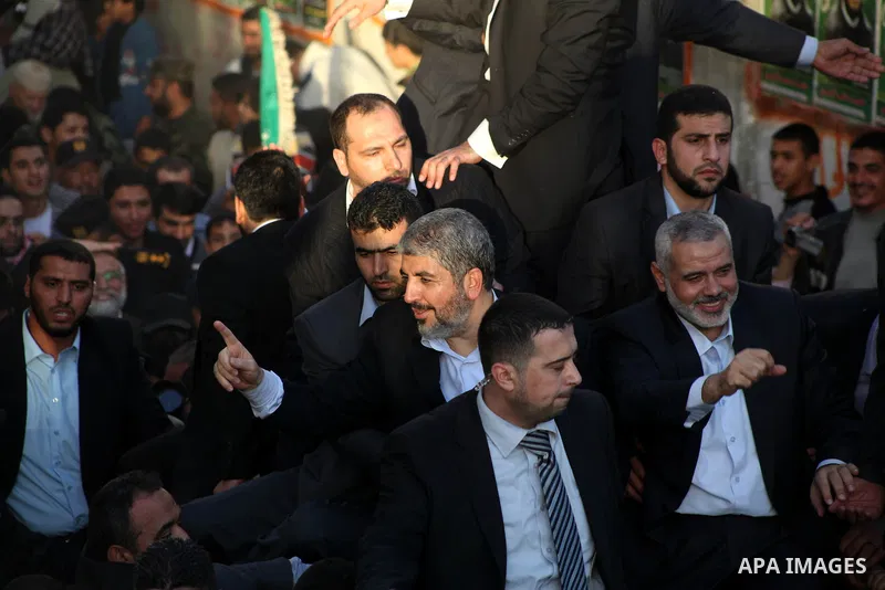 Hamas chief Khaled Meshaal, riding in a car with Palestinian prime minister in Gaza Strip Ismail Haniyeh, waves to the crowd upon his arrival in Gaza City December 7, 2012. Meshaal is making his first-ever visit to the G...