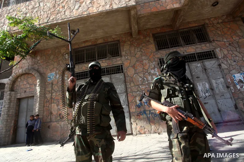 Masked Hamas security men stand guard during a parade following the arrival of Hamas leader-in-exile Khaled Meshaal in Rafah, southern Gaza, on December 7, 2012. Meshaal is making his first-ever visit to the Gaza Strip a...