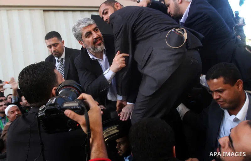 Hamas chief Khaled Meshaal, riding in a car with Palestinian prime minister in Gaza Strip Ismail Haniyeh, waves to the crowd upon his arrival in Gaza City December 7, 2012. Meshaal is making his first-ever visit to the G...